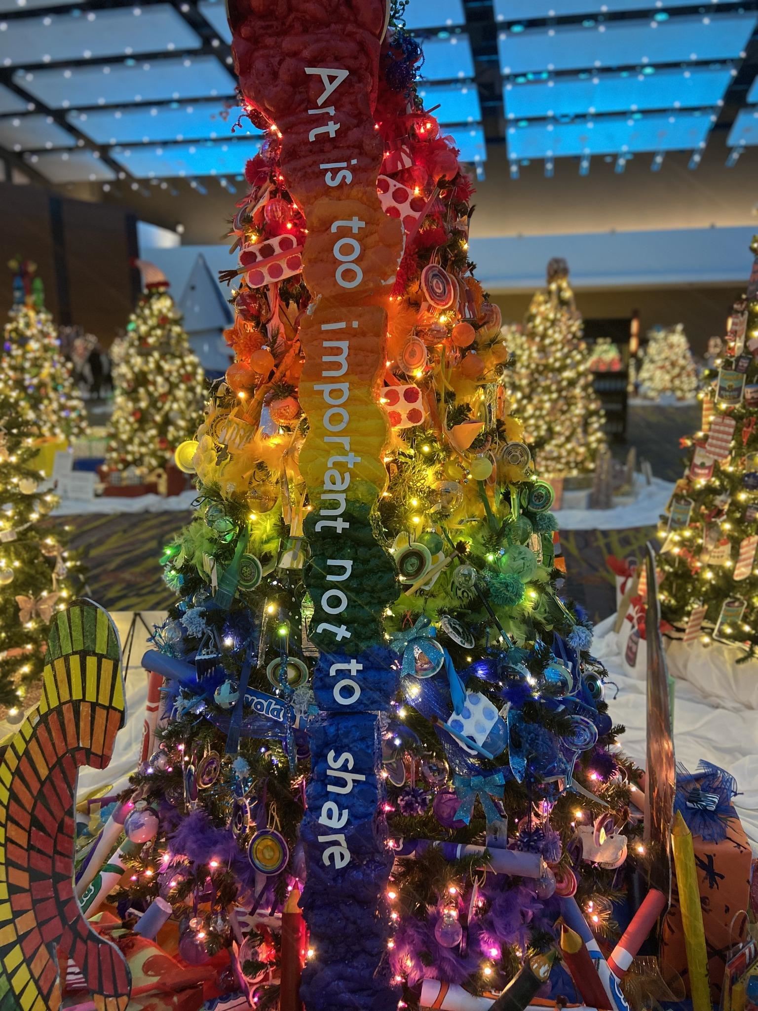 brightly colored tree featuring student made ornaments and materials